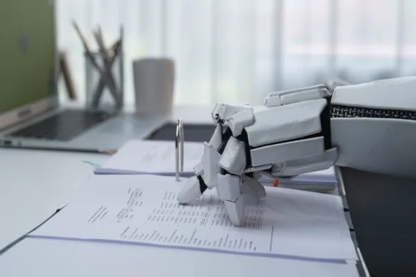 Robotic Arm Holding Pen Above Documents on Modern Office Desk