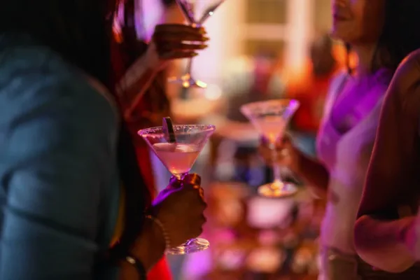 Close Up of A Martini Glass Held By A Female At A Bar