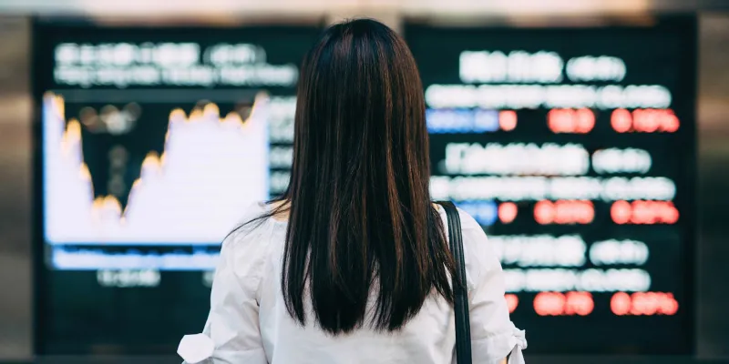  woman looking at stock exchange market display