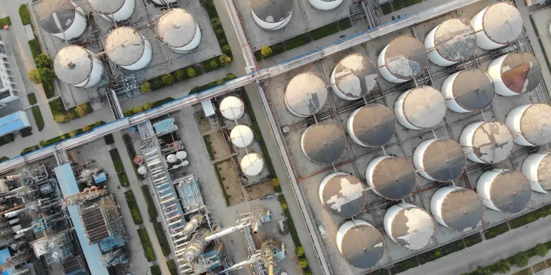 Aerial view of an industrial facility with large storage tanks and surrounding infrastructure.