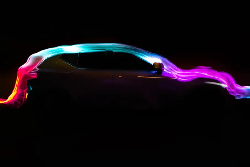 Modern car with aerodynamic colorful light trail at night.